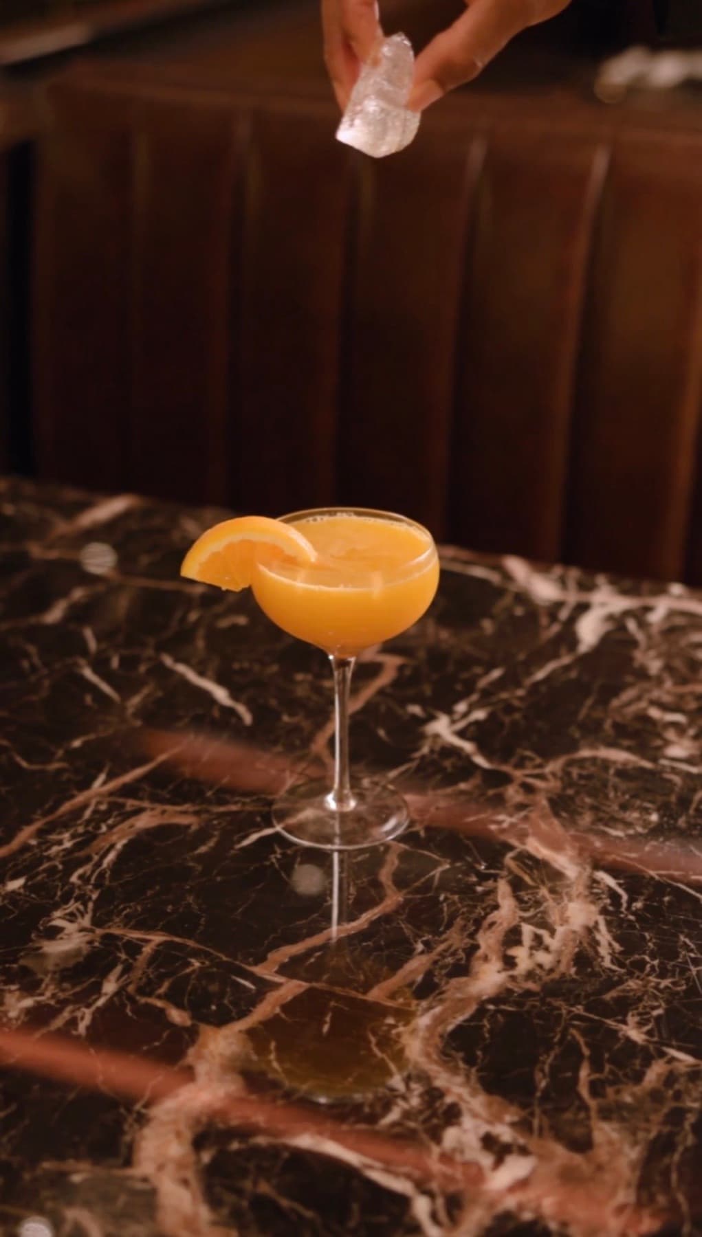 Signature orange cocktail on dark marble